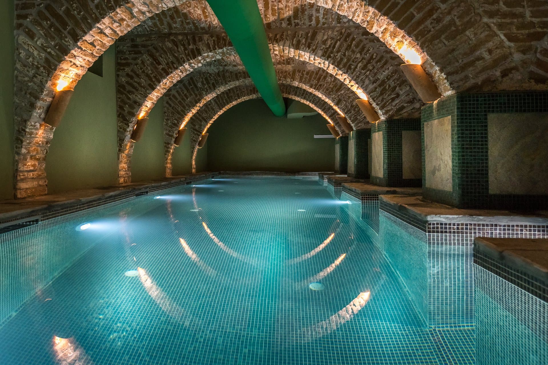 The Cellarium Slow Down Spa with vaulted stone arches and illuminated pool